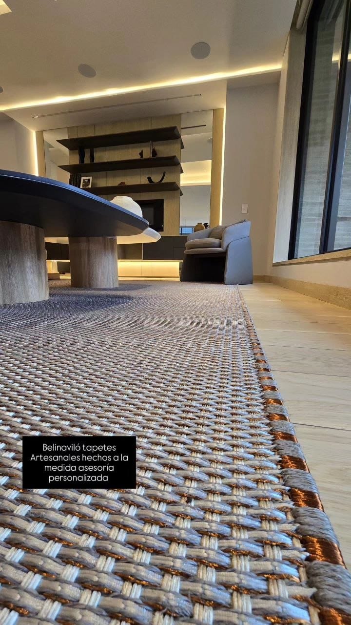 Primer plano de la textura de una alfombra artesanal de color gris carbón con hilos metálicos de estaño incorporados